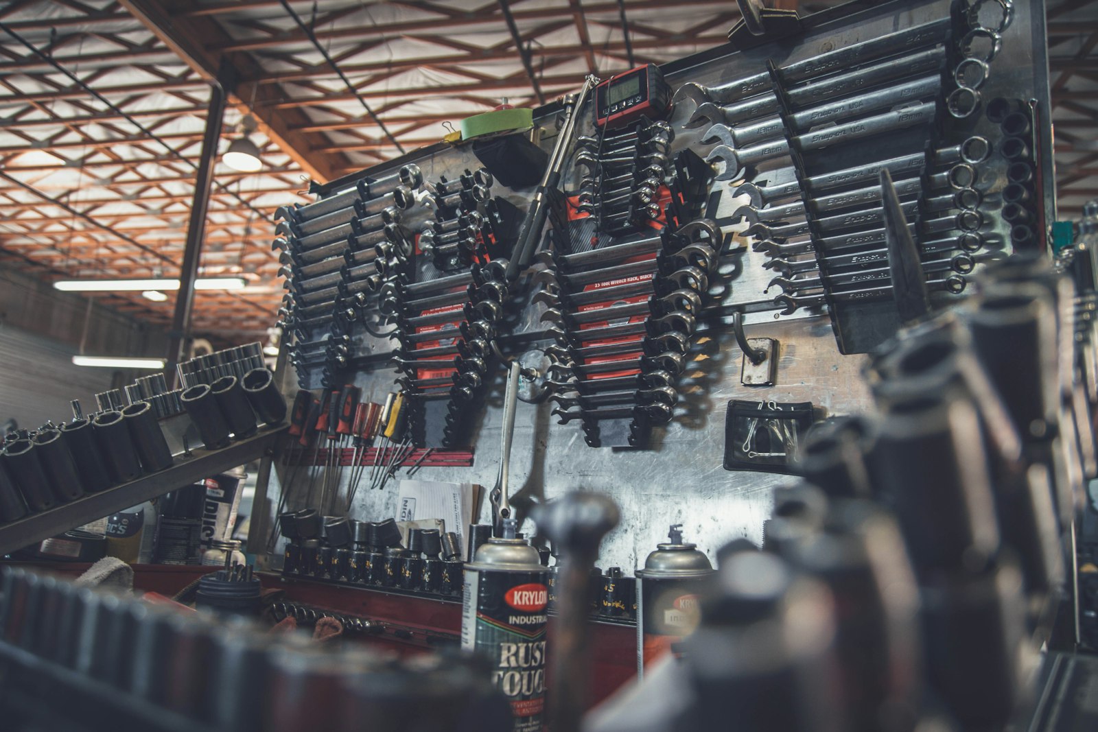 A workshop wall rack filled with wrenches, sockets and hand tools.